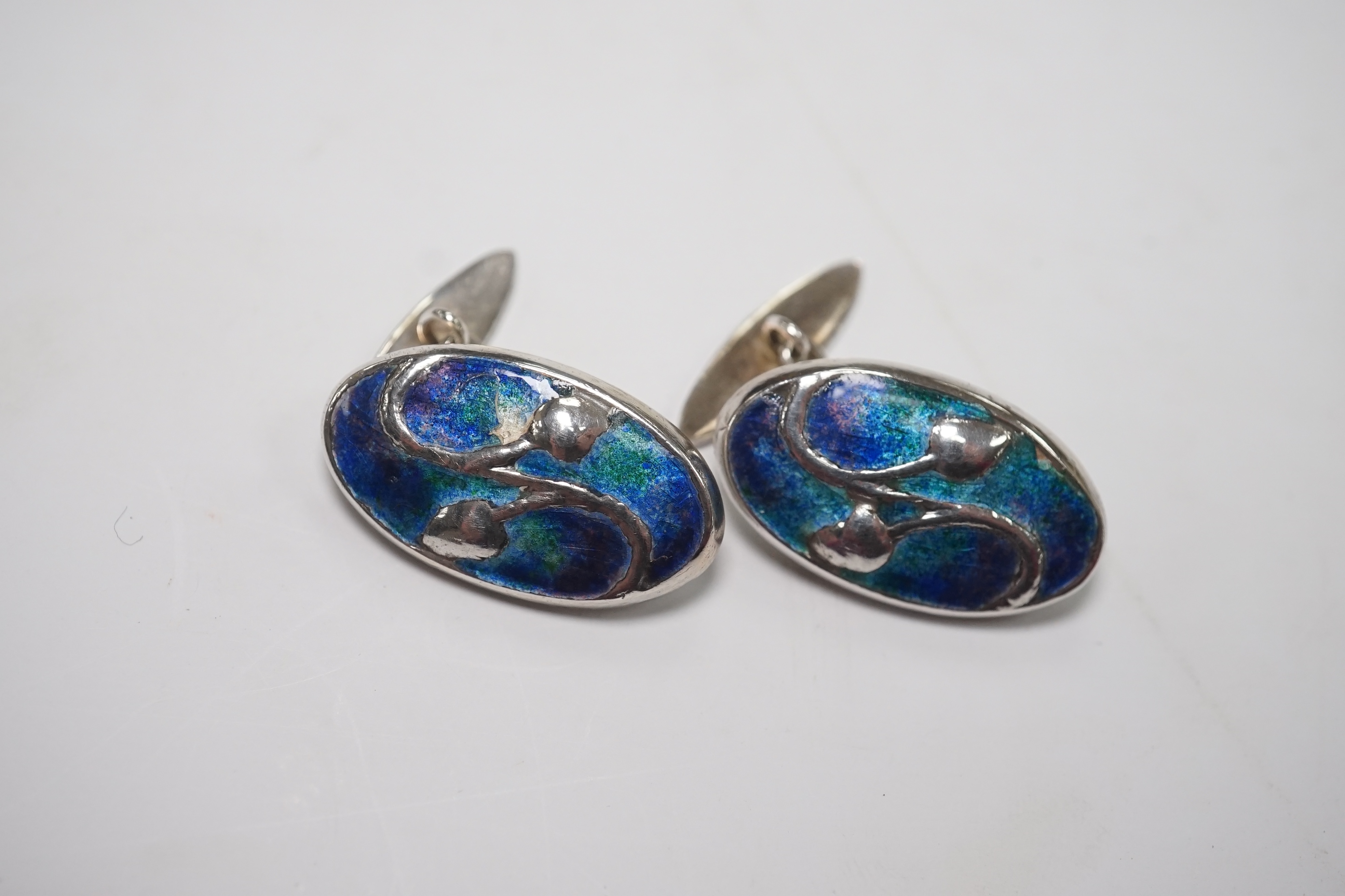 A pair of Edwardian Art Nouveau silver and enamel oval cufflinks, by Liberty & Co Ltd, 23mm, together with a garnet set bar brooch and a Hunt & Roskell box. Condition - poor to fair